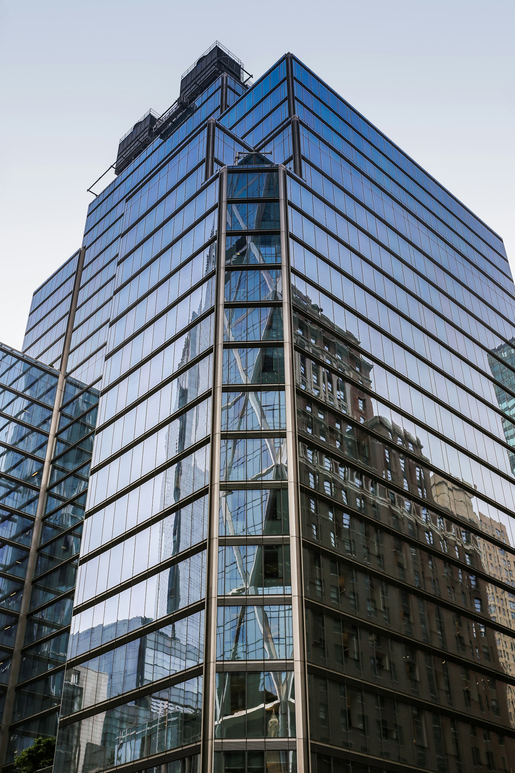 Modern glass office architecture reflecting a blue sky